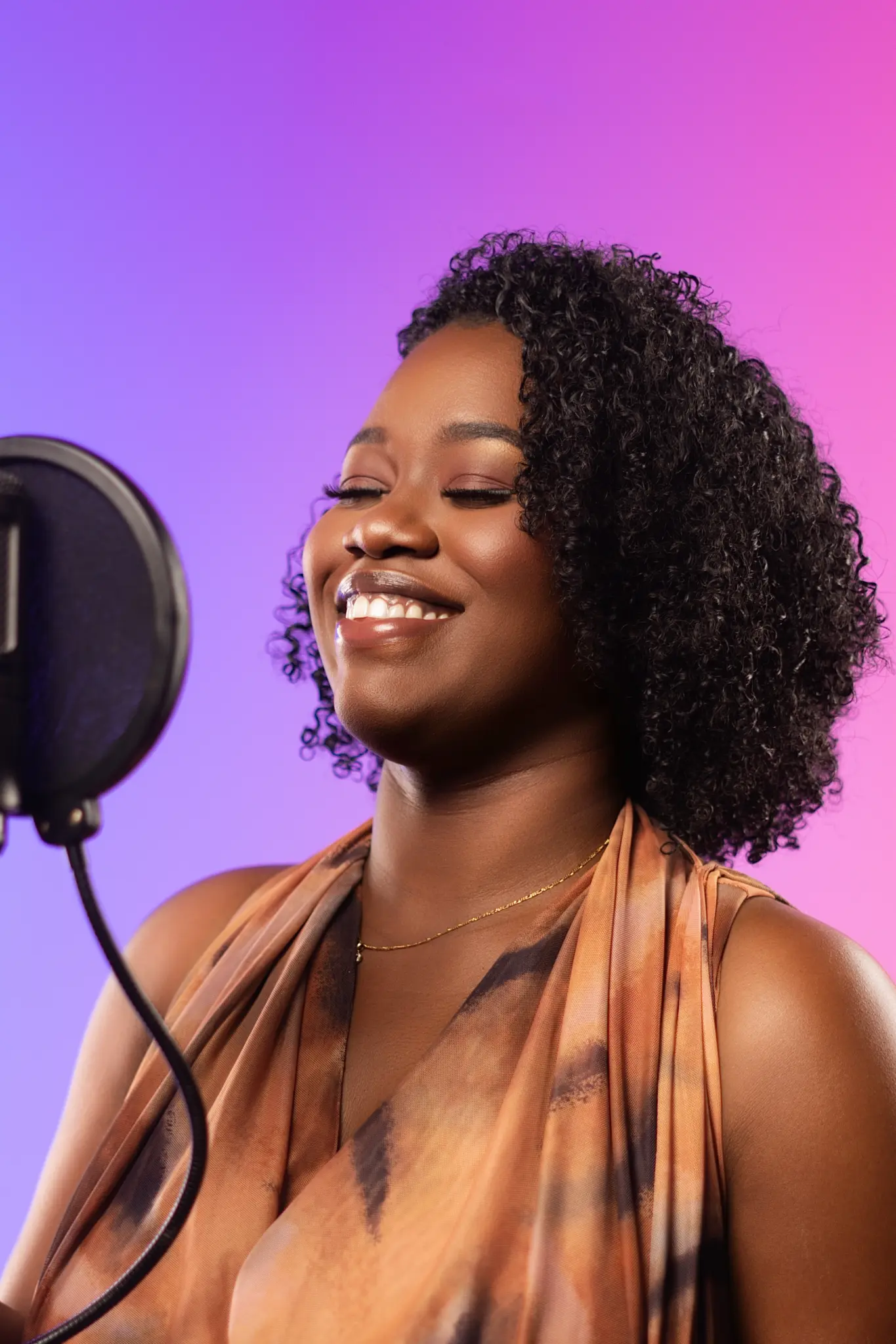 Faith James smiling beside a studio microphone